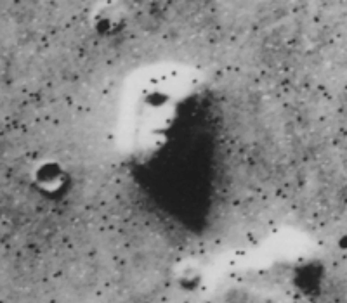 Foto de uma formação geológica em Marte que aparenta uma face humana quando vista por certos satélites
