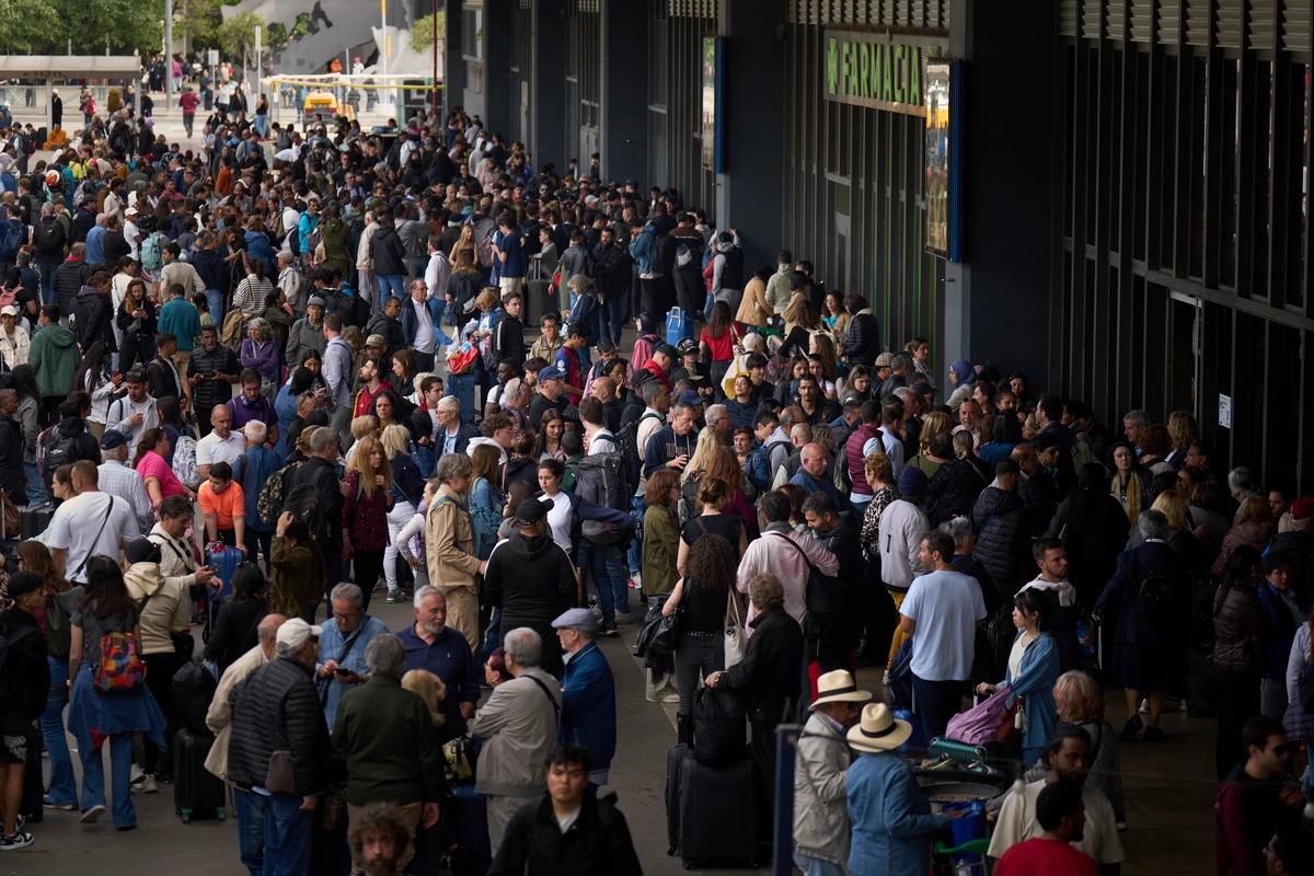 Pessoas esperam do lado de fora de estação de trem fechada durante queda de energia em Barcelona, Espanha