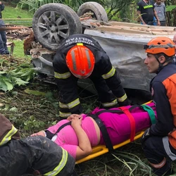 Veículo ficou com as rodas para cima e foi amarrado a um coqueiro para não descer no declive; condutora contou que perdeu o controle da direção devido à água na pista