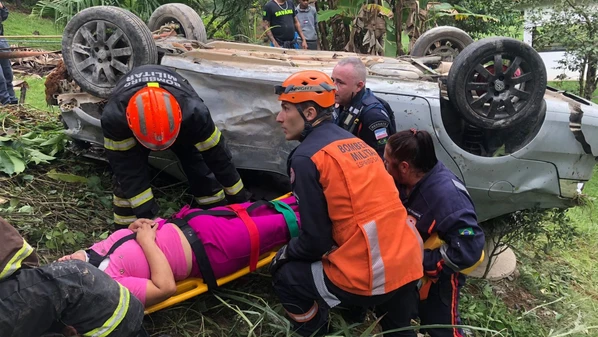 Veículo ficou com as rodas para cima e foi amarrado a um coqueiro para não descer no declive; condutora contou que perdeu o controle da direção devido à água na pista