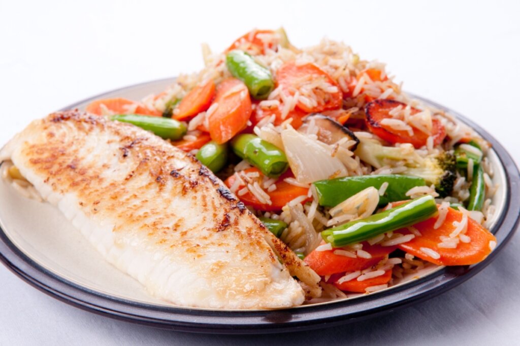 Filé de tilápia com arroz e legumes (Imagem: Wirestock Creators | Shutterstock) 