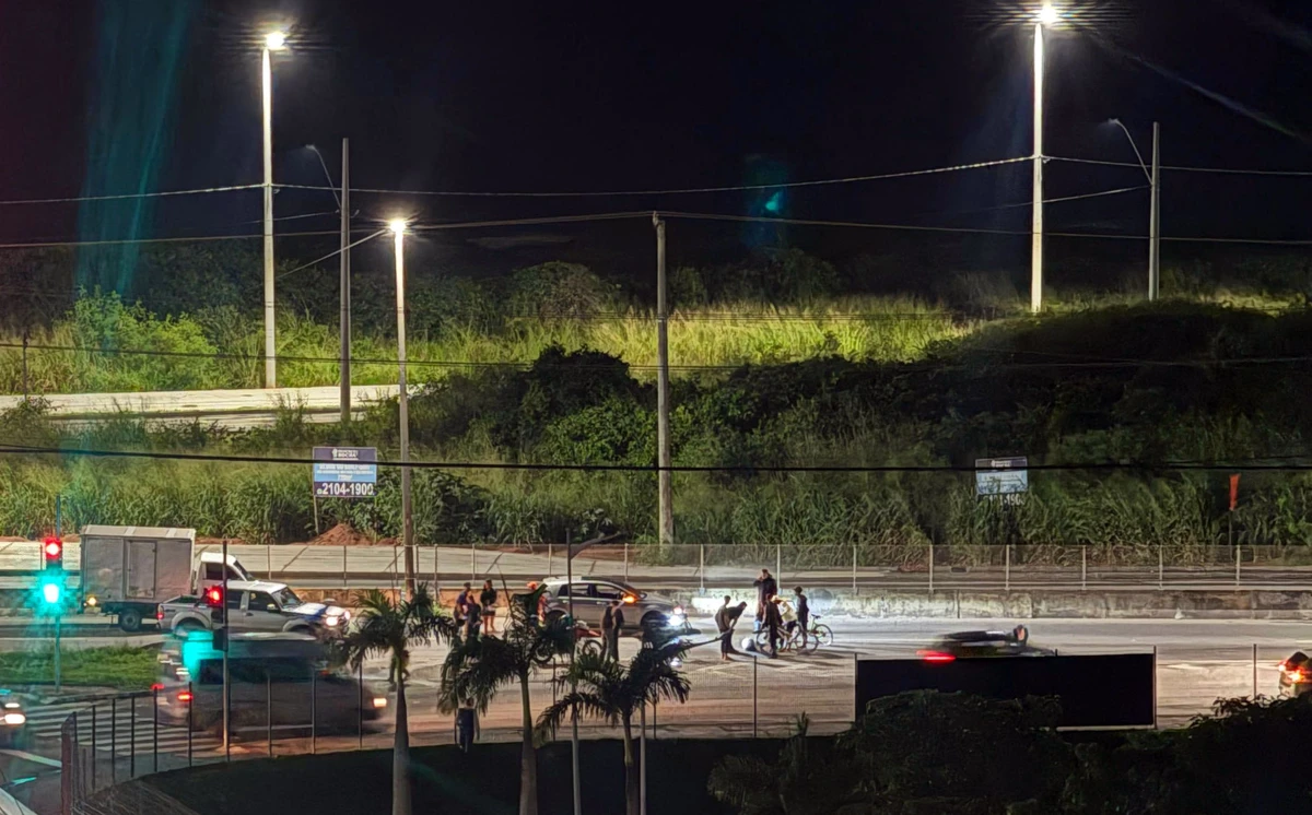 Jovem sendo ajudado por populares e policiais após atropelamento