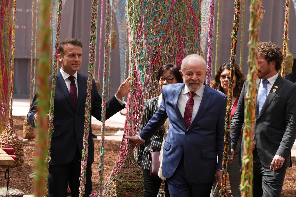 Os presidentes Luiz Inácio Lula da Silva (c), do Brasil, e Emmanuel Macron (e), da França, visitam a exposição 