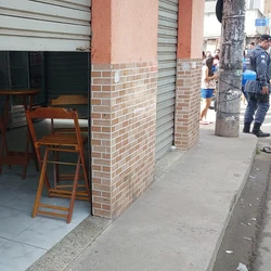 Criminosos atiraram pela rua principal do bairro; homem morreu dentro da padaria e a mulher, baleada ao tentar comprar pão, foi socorrida ao hospital
