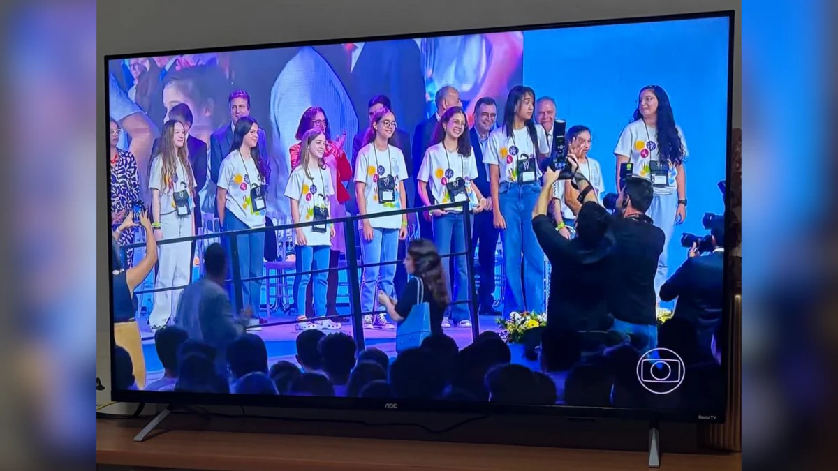 Família assistindo a estudante ser premiada no Jornal Nacional.