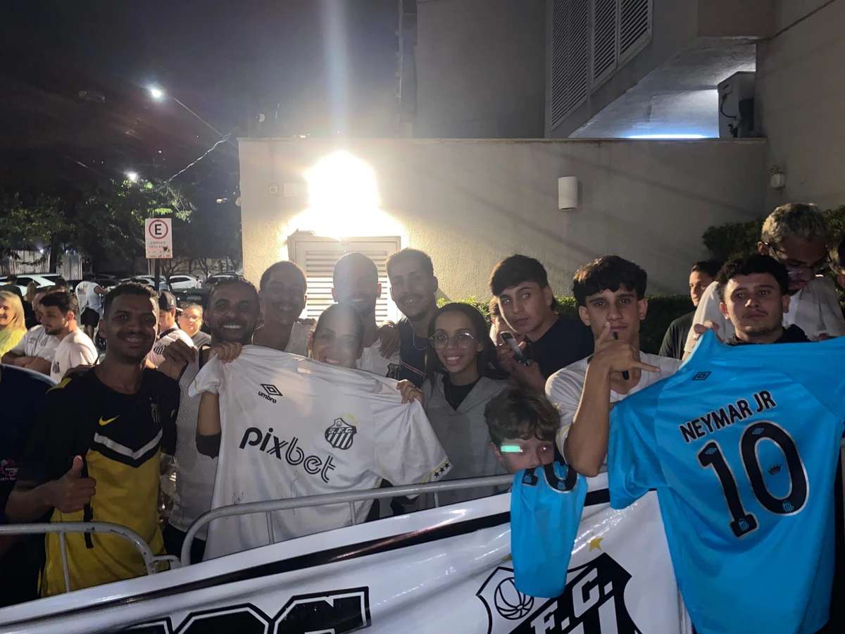 Tatiane do Vale com a camisa do Santos autografada e outros torcedores na chegada do clube em Vitória