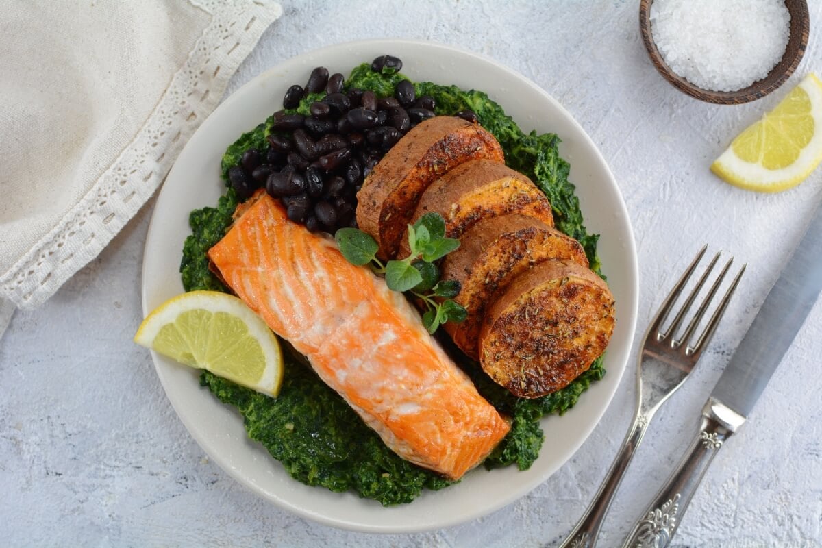 Salmão grelhado com batata-doce assada, espinafre refogado e feijão-preto (Imagem: Azra H | Shutterstock) 