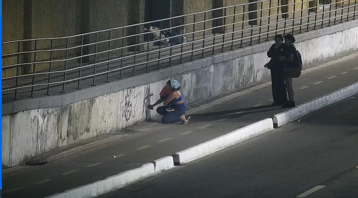 Mulher realizou a pichação enquanto levava uma criança no colo. Ela foi detida