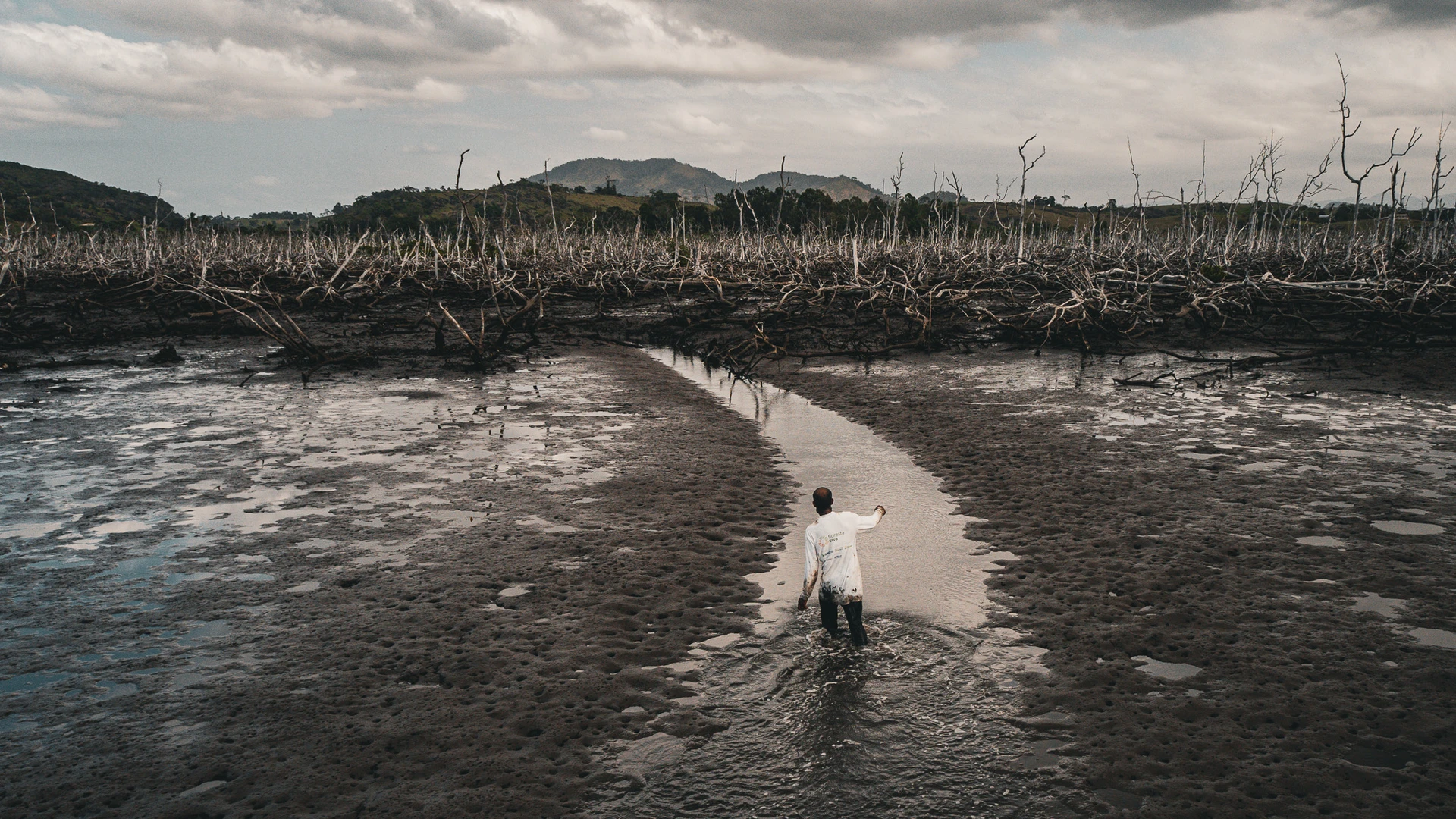 Messac Vasconcelos, pescador, caminha sobre o que restou do mangue