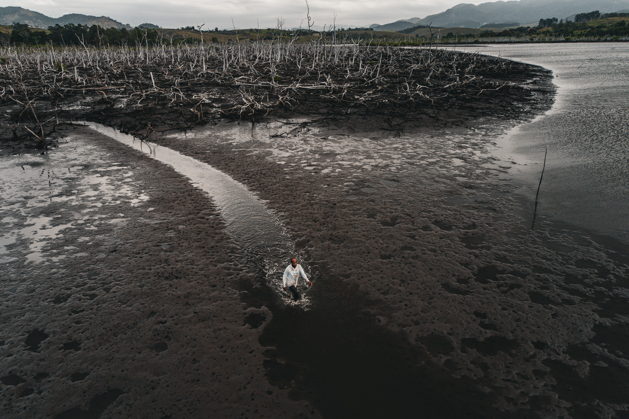 Messac Vasconcelos, pescador, caminha sobre o que restou do mangue