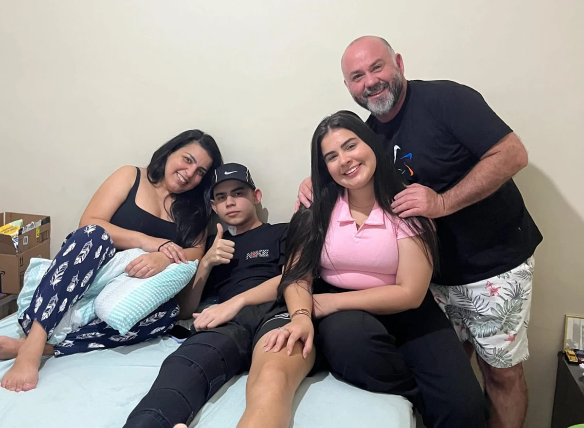 Miguel Bazoni, de 15 anos, diagnosticado com osteossarcoma, entre a família.