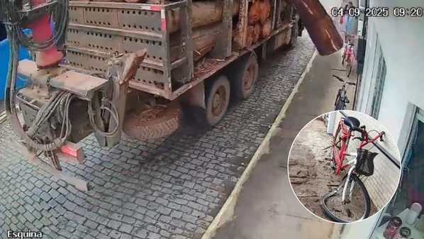 Câmeras flagraram o momento em que parte da carga se desprendeu; calçada e bicicleta ficaram danificadas