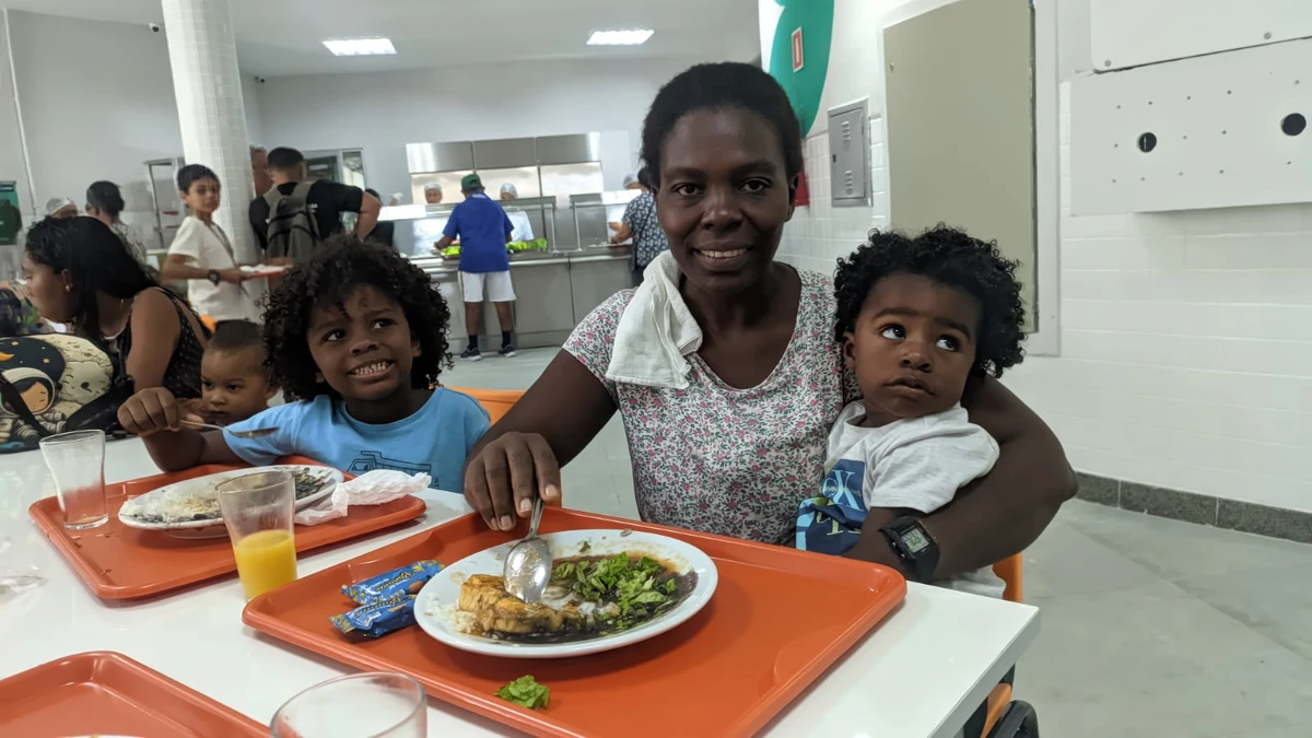 Cristiane Costa e os filhos Miguel Angelo e Luan saboreando a comida na inauguração do restaurante popular de Vitória nesta sexta-feira (5)