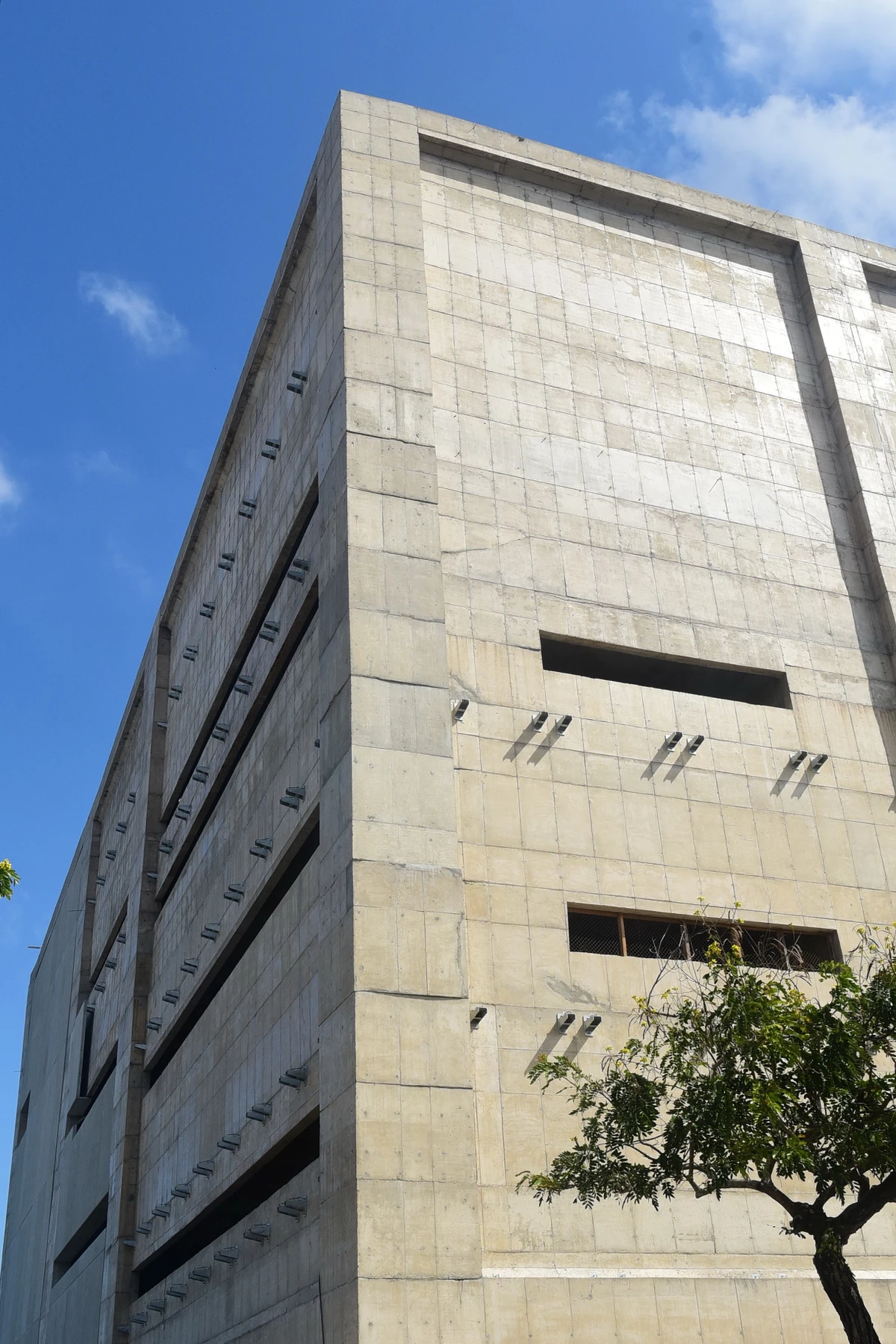 Trabalhadores durante o processo para revestir as parades do Cais das Artes. Primeiro colocam suportes metálicos que vao receber as placas de revestimento. Na foto já aparece parte da parede com as placas. por Carlos Alberto Silva