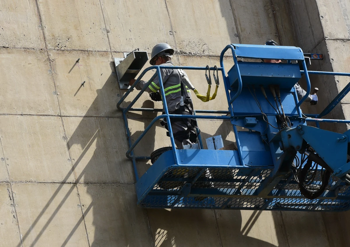 Trabalhadores durante o processo para revestir as parades do Cais das Artes. Primeiro colocam suportes metálicos que vao receber as placas de revestimento.  por Carlos Alberto Silva