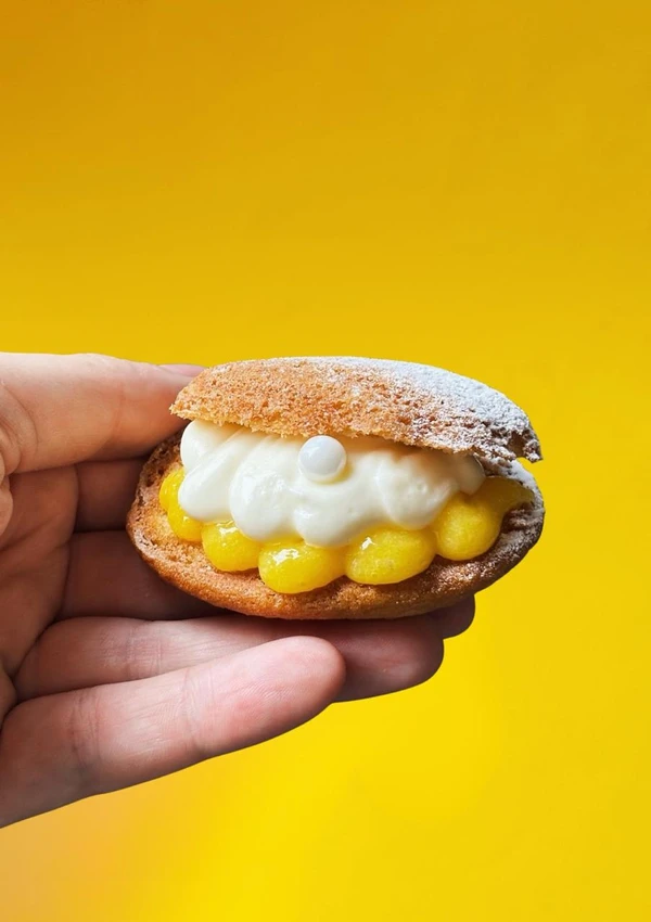 Madeleine recheada com curd de maracujá e chantili de baunilha (R$ 16) Foto por Charles Bringer