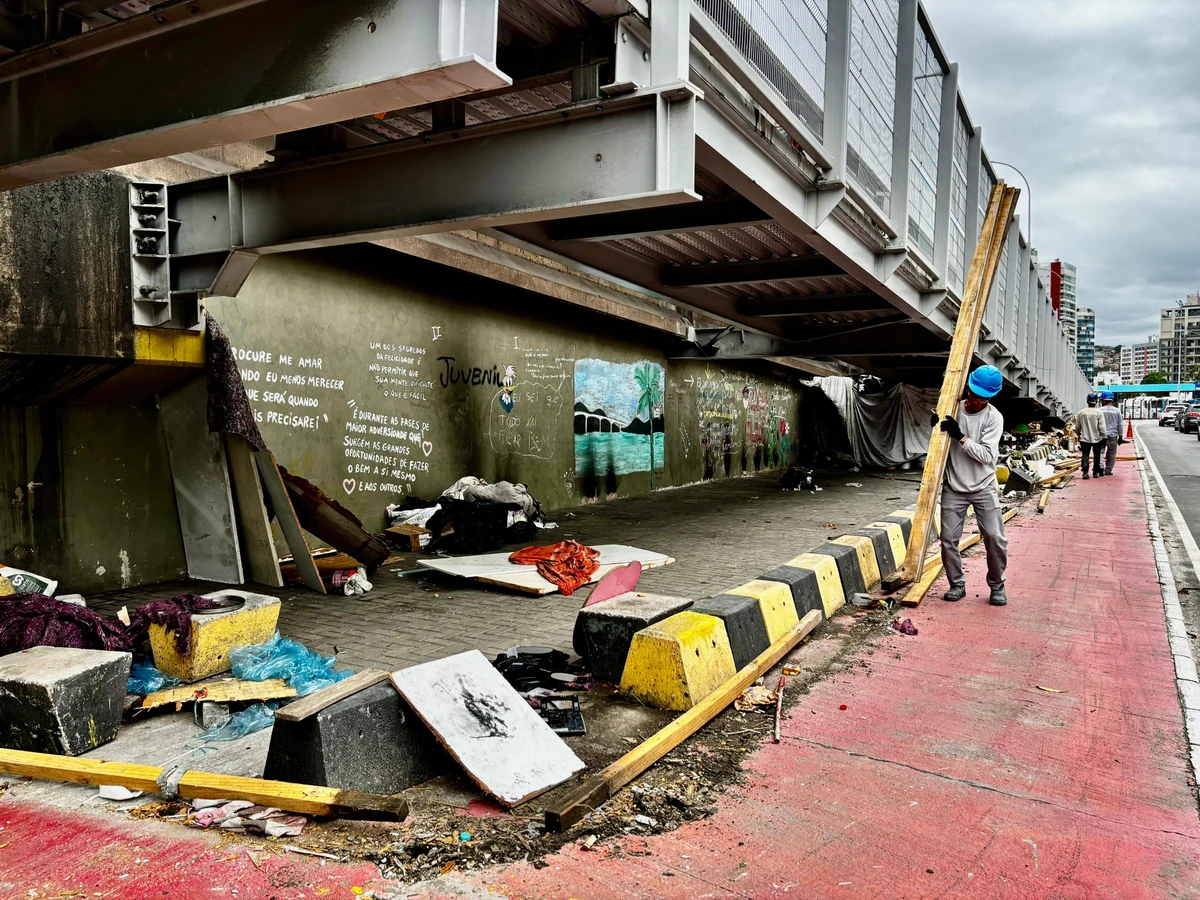 Homens trabalham no desmonte de abrigos e limpeza embaixo da ciclovia da Terceira Ponte, lado Vitória