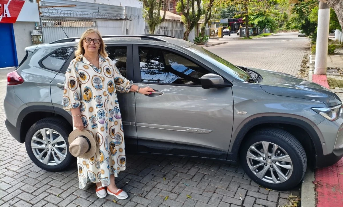 Márcia Abrahão e o carro com o qual transporta idosos