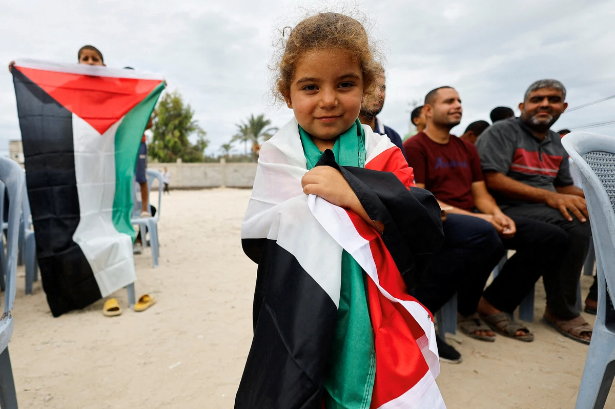 A girl holds a Palestinian flag, after U.S. President Donald Trump announced that Israel and Hamas 