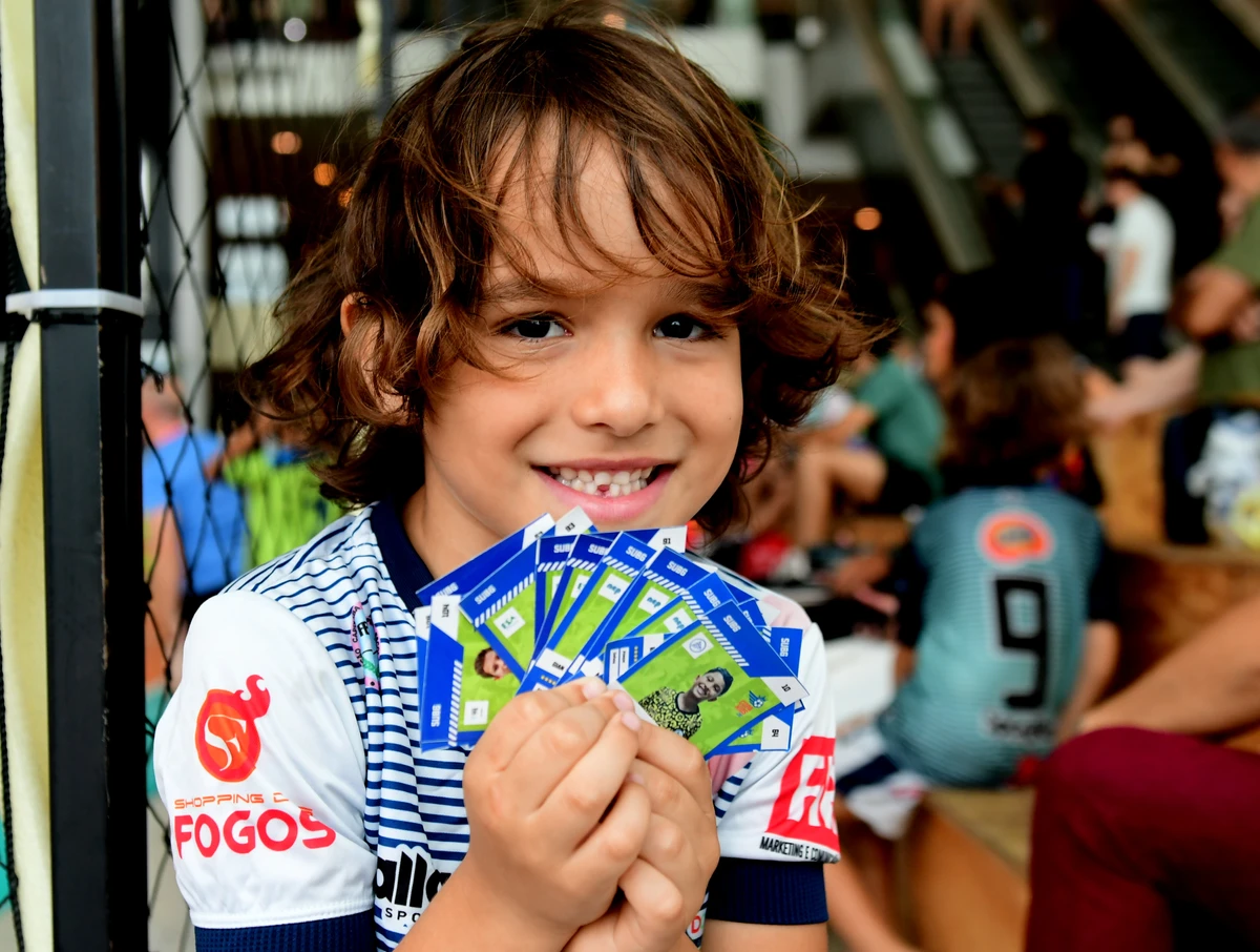 Crianças disputam torneio de futsal e podem colecionar suas próprias figurinhas