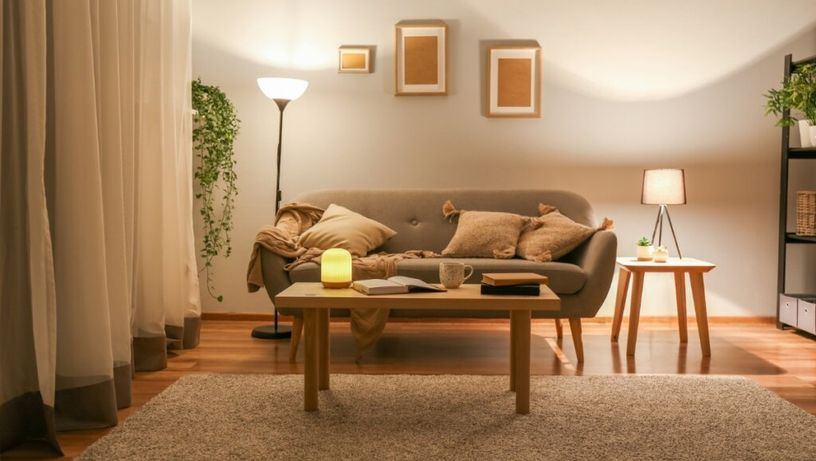 Luzes amareladas e indiretas ajudam a criar uma atmosfera acolhedora e relaxante na sala de estar (Imagem: Pixel-Shot | Shutterstock)