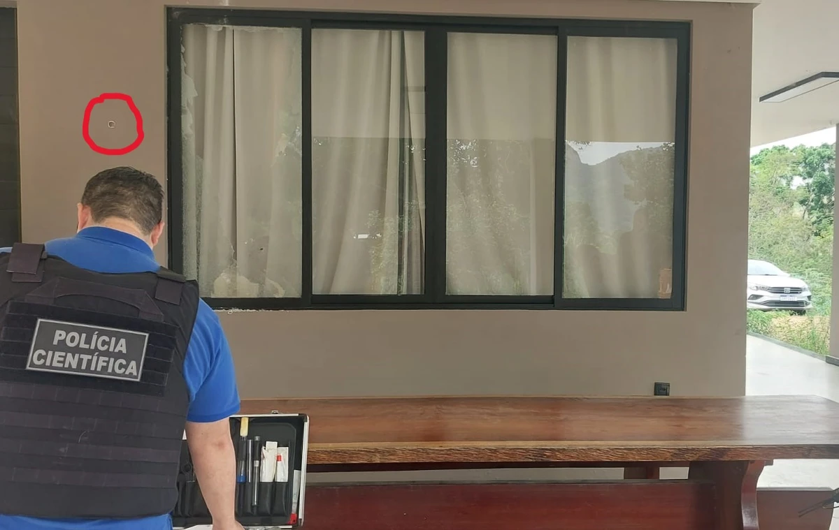 Polícia Científica faz perícia na residência de empresário baleado em Cariacica; parede do imóvel ficou com marcas de tiro (no detalhe)