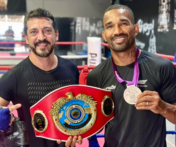 Esquiva Falcão mostra o Cinturão e medalha à aluno em sua academia de boxe 'Esquiva Falcão Boxing Gym'