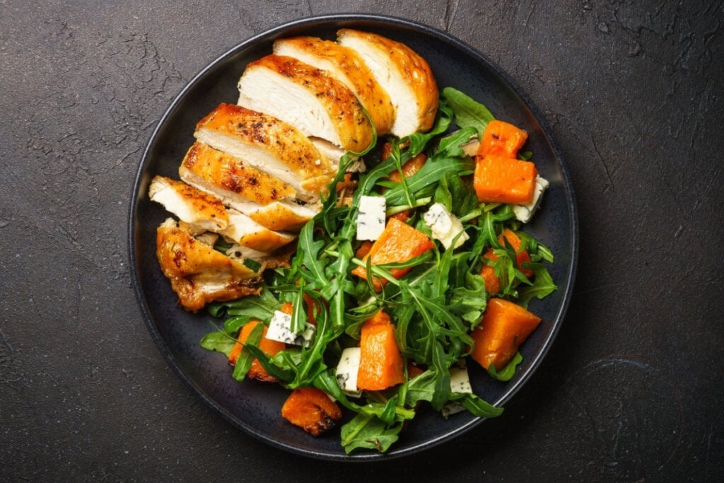 Peito de frango grelhado com salada de rúcula, abóbora e queijo (Imagem: nadianb | Shutterstock)