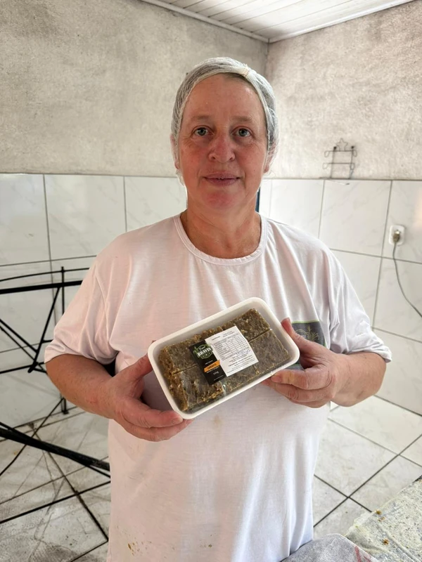 Rosana com a bandeja de pedaços de carrapito, doce feito de forma artesanal