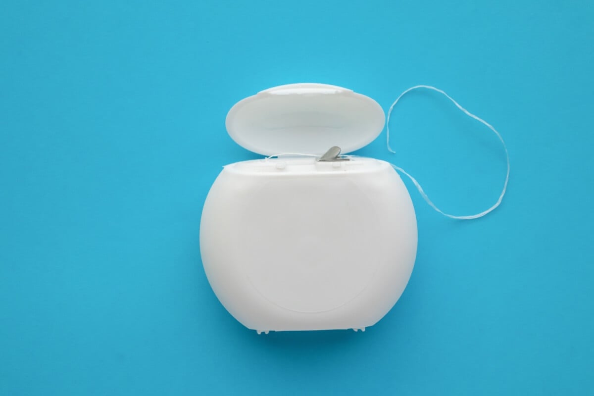 O uso do fio dental diariamente ajuda a manter a saúde da boca (Imagem: Kwangmoozaa | Shutterstock)
