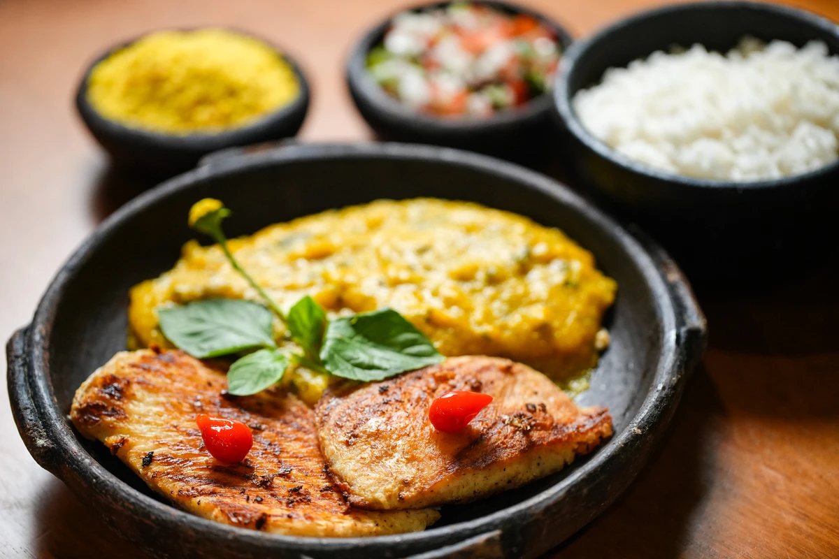 Filhote na grelha servido com pirão, arroz, farofa e vinagrete Foto por Vitor Jubini
