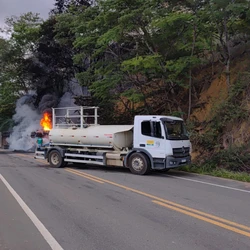 Chamas foram contidas com auxílio de um caminhão-pipa da prefeitura; motorista conseguiu sair antes que o fogo se espalhasse, mas ficou ferido e foi levado para um hospital