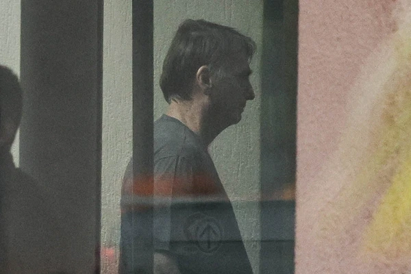 O ex-presidente Jair Bolsonaro é visto através do vidro da sede da Polícia Federal, em Brasí­lia 