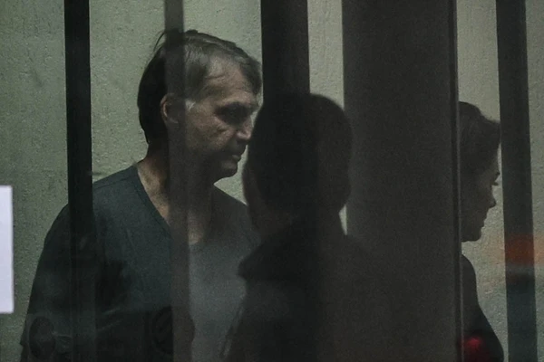O ex-presidente Jair Bolsonaro é visto através do vidro da sede da Polí­cia Federal
