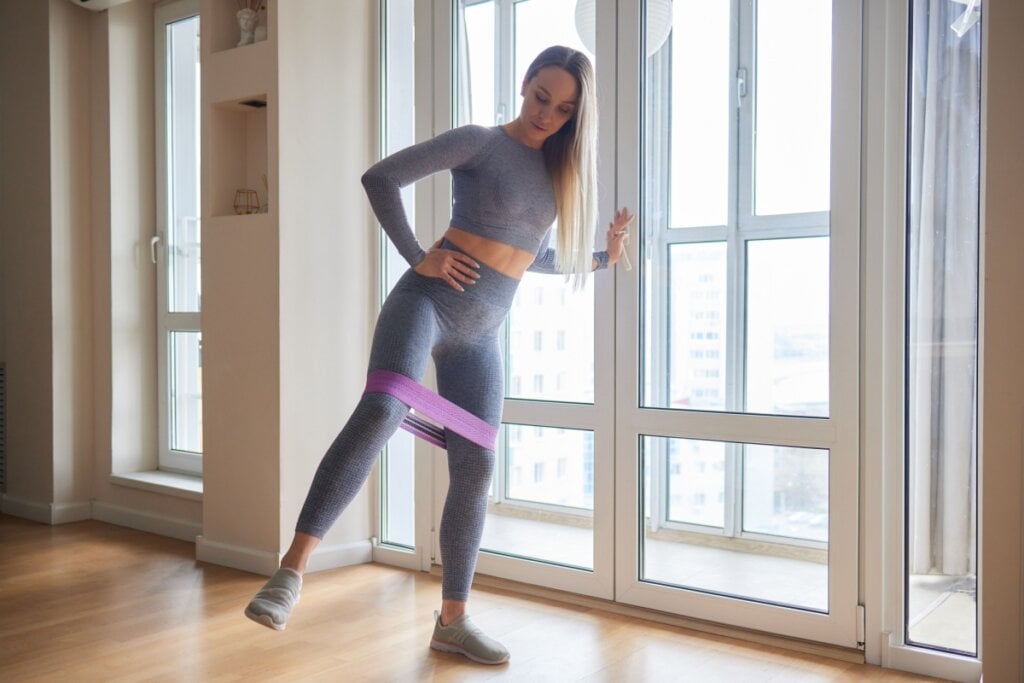 No exercício de abdução em pé com apoio, a perna não precisa subir muito (Imagem: Vershinin89 | Shutterstock)