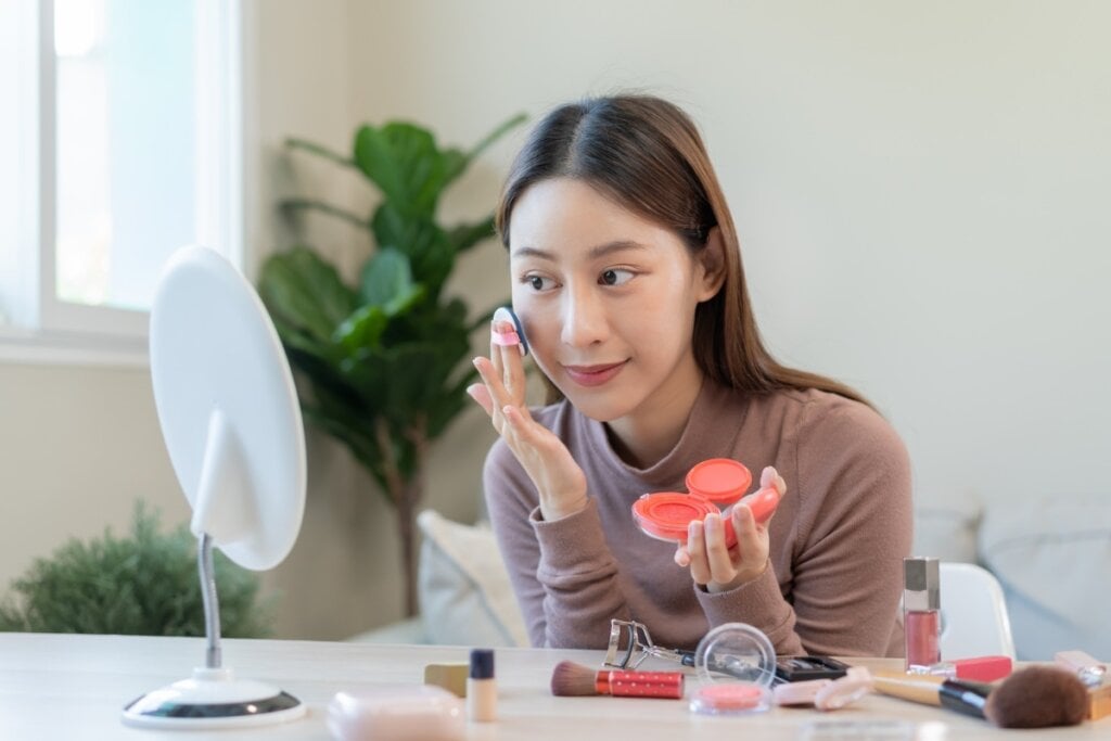 Aplicar uma versão cremosa de blush, bronze e iluminador e, por cima, uma versão em pó ajuda a deixar a maquiagem mais resistente (Imagem: Kmpzzz | Shutterstock) 