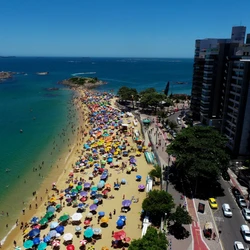 Banhistas aproveitam o domingo de altas temperaturas, e imagens mostram praias cheias e tomadas pelas barracas coloridas nas duas cidades