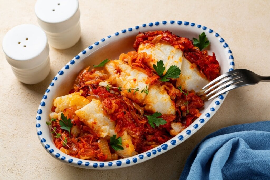Bacalhau assado no molho de tomate (Imagem: OlgaBombologna | Shutterstock)