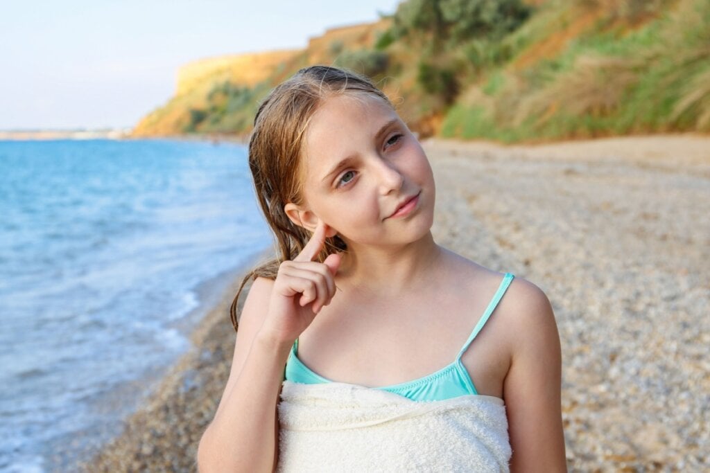 Posicionar a cabeça de lado e puxar a orelha devagar pode facilitar a saída da água no ouvido (Imagem: Victoria 1 | Shutterstock)