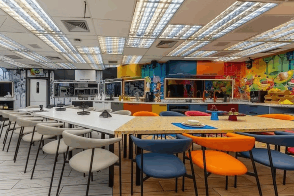 A cozinha integrada do BBB 26 reforça a ideia de delimitar ambientes sem paredes, usando mobiliário e cores para organizar o espaço (Imagem: Reprodução digital | TV Globo/Beatriz Damy)