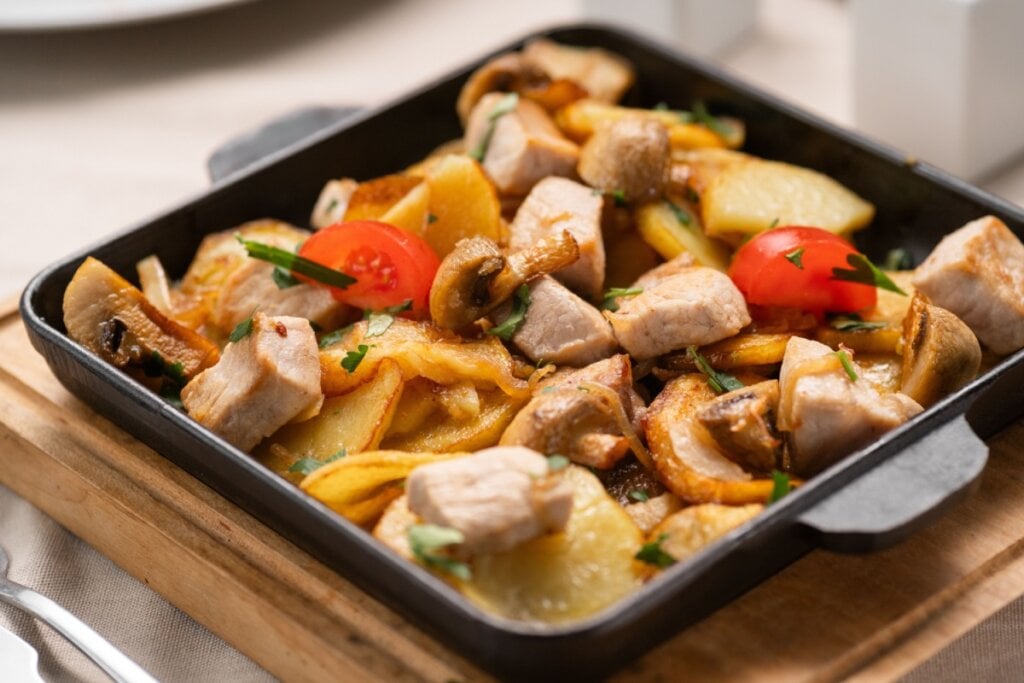 Frango assado com batatas e cogumelos (Imagem: Lysenko Andrii | Shutterstock)