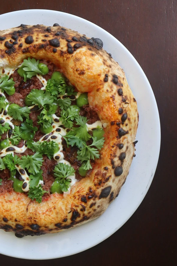 Carne-seca: molho de tomate, muçarela, carne-seca, banana-da-terra, cream cheese e veluté de agrião (R$ 84) Foto por Acervo/Pocar