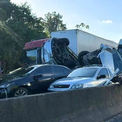 Engavetamento ocorreu na tarde de quinta-feira (12) e três pessoas se feriram; carreta carregada com cerveja não conseguiu parar no trecho em "pare e siga" e bateu nos veículos à frente