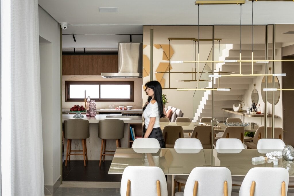 A porta com vidro reflecta separa os ambientes sem pesar, amplia a luz natural e mantém a integração visual do espaço (Projeto: Meneghisso &amp; Pasquotto Arquitetura | Imagem: JP Image)