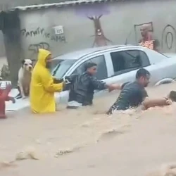 Vídeos que circulam nas redes sociais mostram que três homens deram as mãos contra a correnteza para conseguir alcançar o morador carregado pela enxurrada; depois de resgatado, ele foi levado a um local da rua onde a força da água era menor