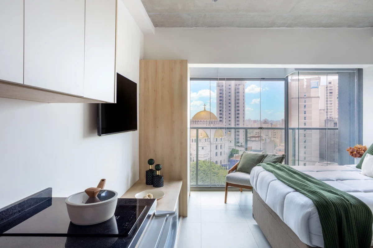 Neste studio de 21m² a arquiteta Natália de Souza aposta na luz natural que adentra o fechamento de vidro na varanda