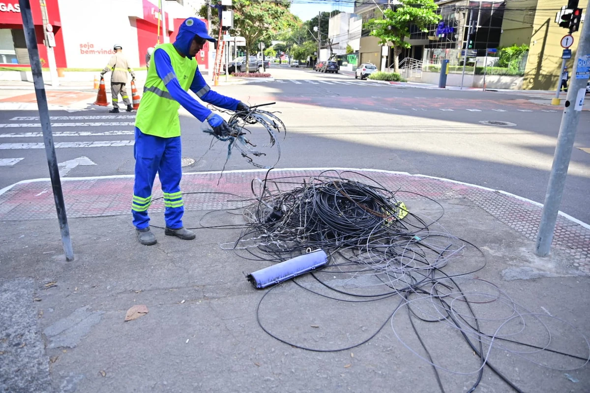 Operário diante de material inativo retirado de postes da Praia do Canto