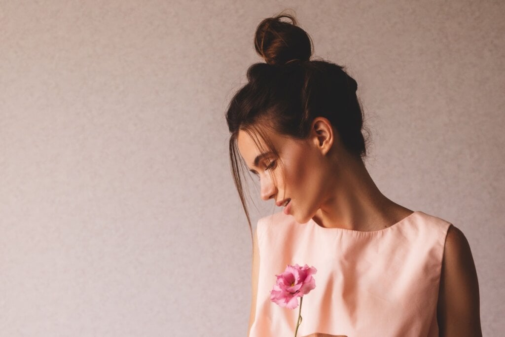 Com um coque preso no topo da cabeça, o penteado garante conforto durante longas horas e ganha leveza com mechas soltas que suavizam o visual (Imagem: Ekateryna Zubal | Shutterstock)