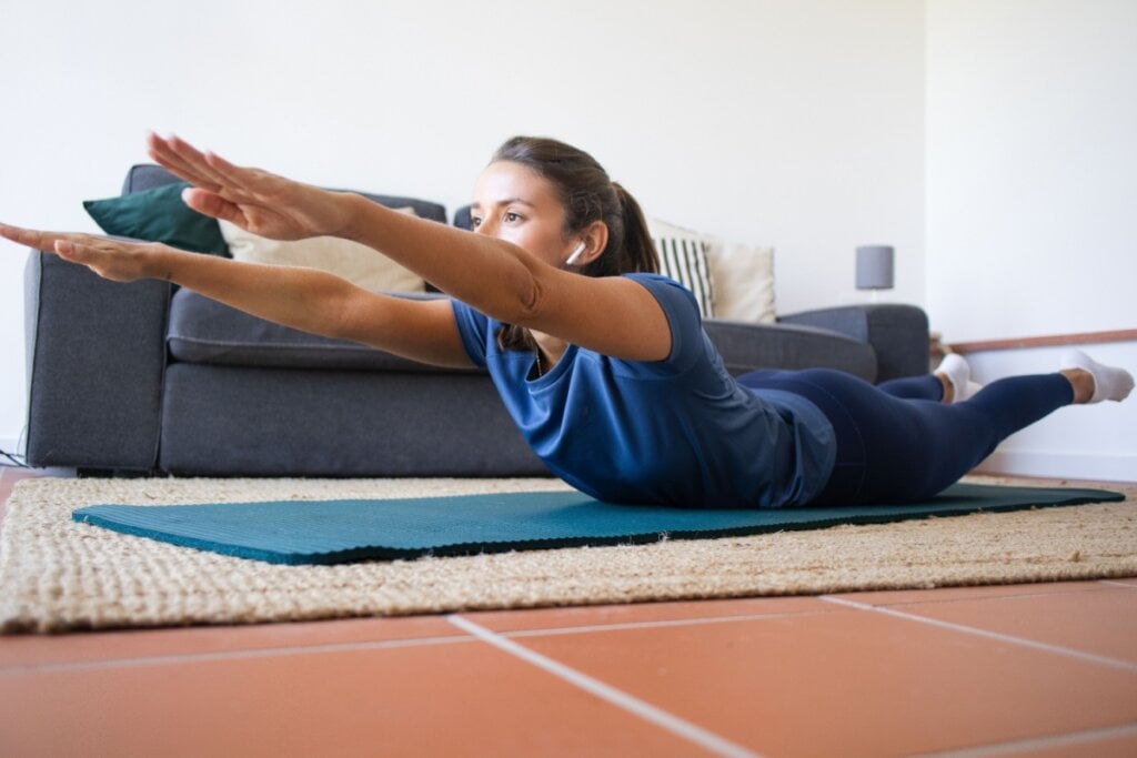 A elevação de braço e perna fortalece a região da lombar (Imagem: Cavan-Images | Shutterstock)