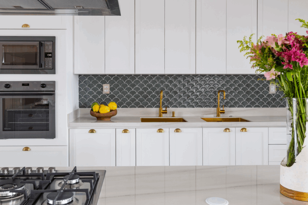 O uso de revestimentos também valoriza cozinhas mais neutras, criando contraste com metais e marcenaria e reforçando o estilo do espaço (Projeto: Mari Milani | Imagem: Mariana Camargo)